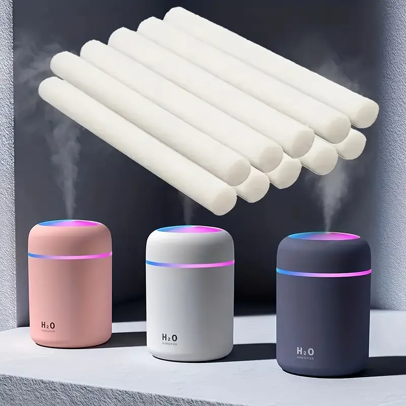 A small USB humidifier placed beside a laundry basket or on a table, releasing scented mist into a small room or wardrobe.